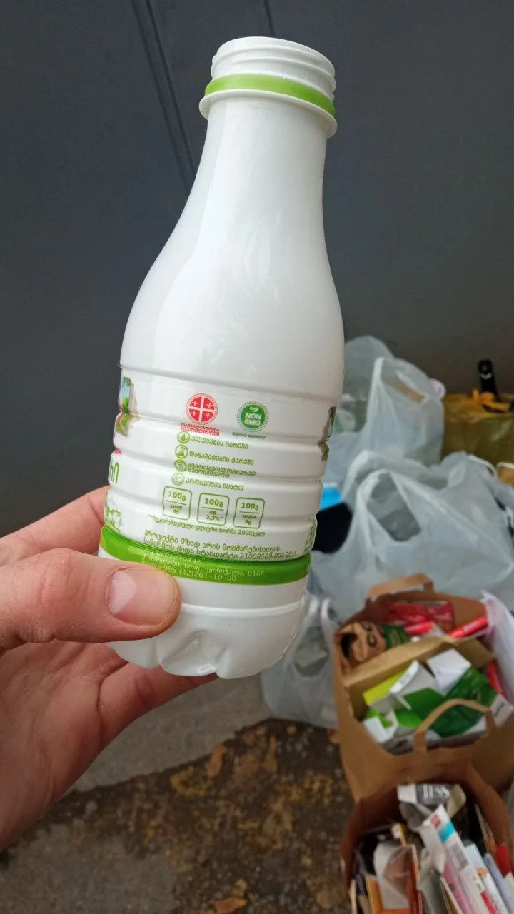 White plastic milk bottle held in hand